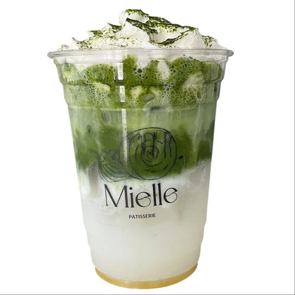 Green tea dessert in a transparent cup with 'Mielle' branding on a white background