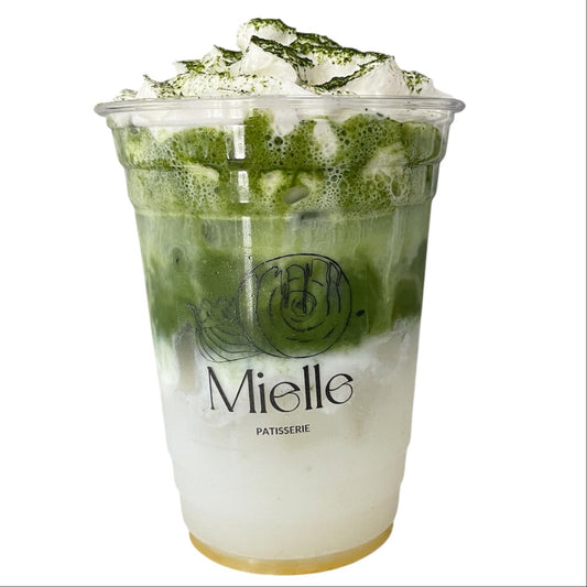 Green tea dessert in a transparent cup with 'Mielle' branding on a white background
